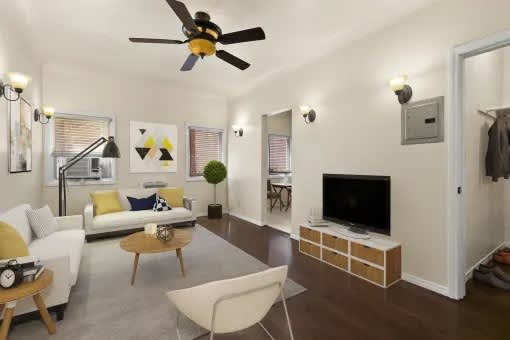 A living room with a white couch, a coffee table, and a ceiling fan.
