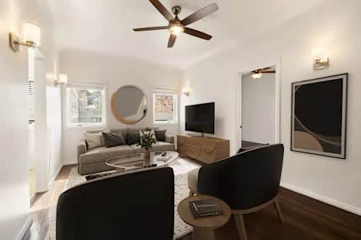 A living room with a black chair and a coffee table.