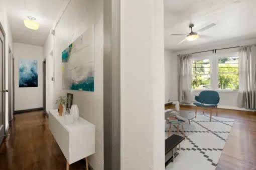 A room with a blue chair and a painting on the wall.