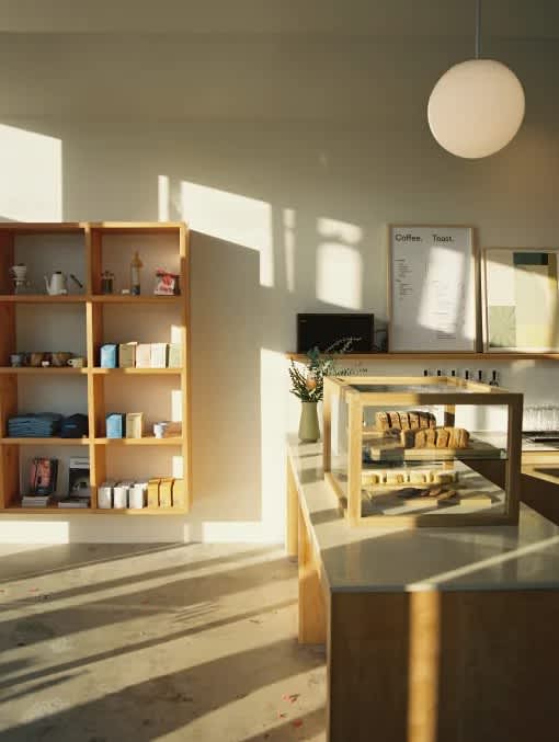 A cafe with a wooden shelf and a glass display case.