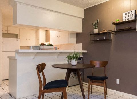 A kitchen with a table and chairs.
