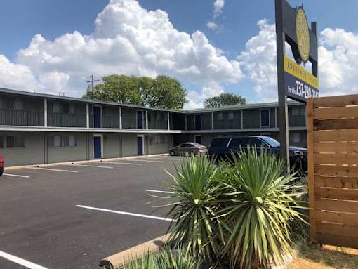 A parking lot with a sign that says Apartment on it.