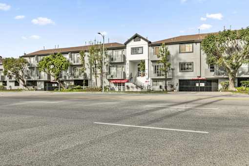 Apartment building with a parking lot in front.
