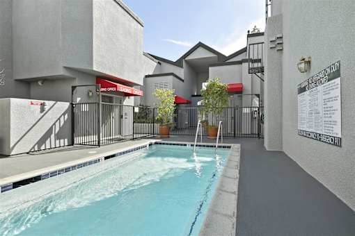 A pool in a residential area with a sign on the wall.