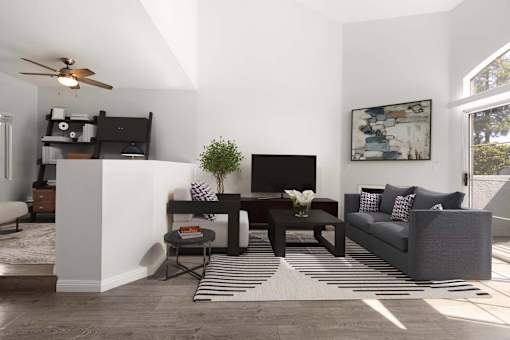 A living room with a grey couch, a black TV, and a striped rug.