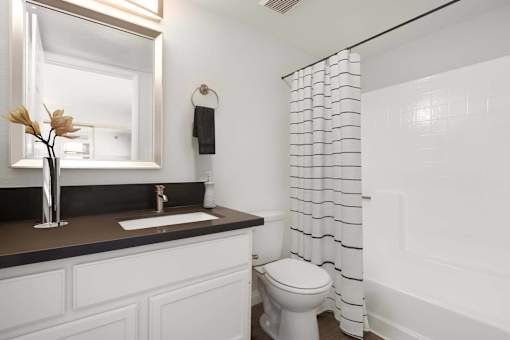 A white toilet sits next to a white sink in a bathroom.