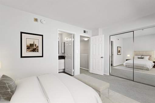A bedroom with a large bed and a picture on the wall.