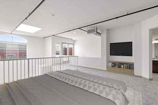 A modern living room with a grey carpet and a black television.