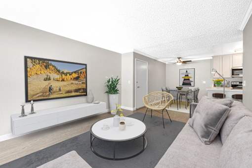 A living room with a grey couch, a white coffee table, and a painting on the wall.