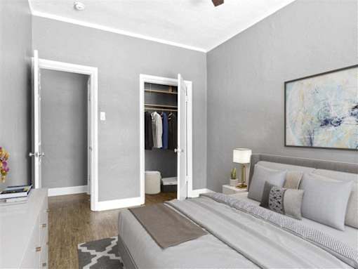 A bedroom with a bed, a nightstand, a dresser, and a painting on the wall.