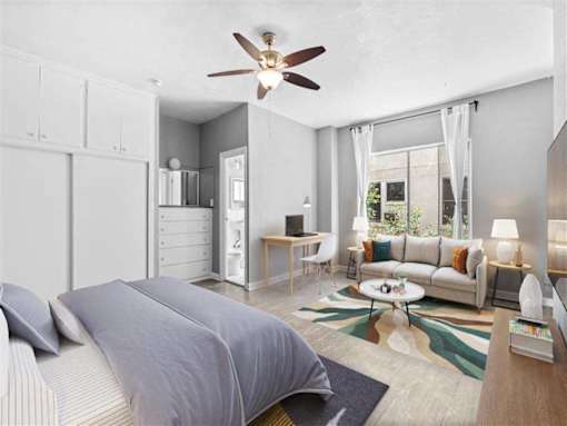 A bedroom with a bed, a ceiling fan, and a window with curtains.