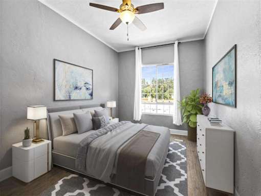 A bedroom with a bed, nightstand, and a ceiling fan.