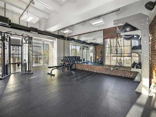 A gym with a brick wall and various exercise equipment.