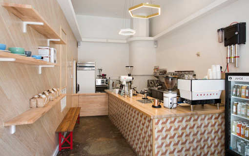 A coffee shop with a wooden counter and a variety of coffee machines.