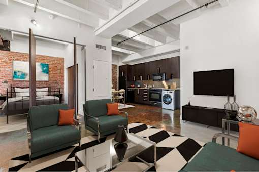 A living room with a black and white checkered rug and a green couch.