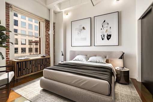 A bedroom with a large bed and two framed pictures on the wall.