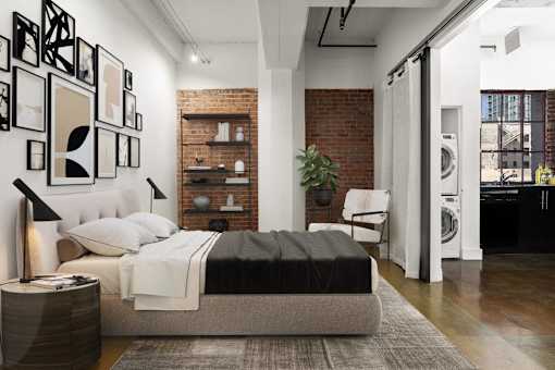 A modern bedroom with a large bed and a brick wall.