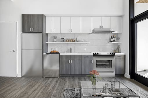 A modern kitchen with a refrigerator, oven, and cabinets.