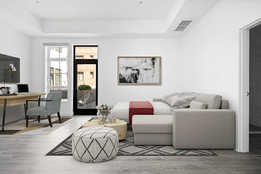 A modern living room with a grey sofa, a red ottoman, and a black and white abstract painting on the wall.