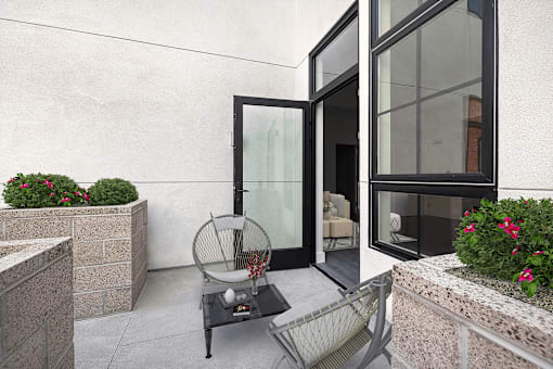 A patio with a table and chairs and a glass door.