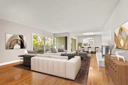 A modern living room with a white sofa and a wooden floor.
