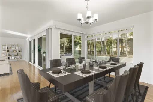 A modern dining room with a large table and chairs.