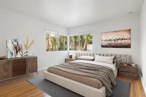 A bedroom with a large bed and a painting on the wall.