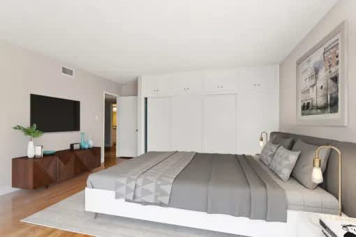 A bedroom with a large bed and a flat screen TV.