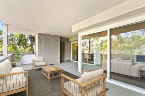 A modern living room with a glass door leading to a balcony.