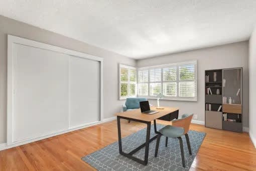 A room with a desk and a chair in it.