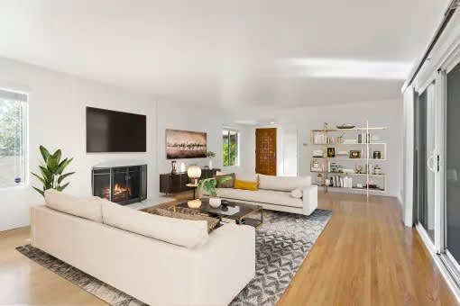 A modern living room with a fireplace and a flat screen TV.