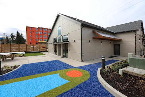 a playground with a blue carpet in front of a building