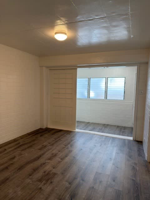 Pacific Oasis bedroom with a sliding door and wood flooring.