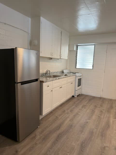 Pacific Oasis kitchen with a stainless steel refrigerator and wooden floors.