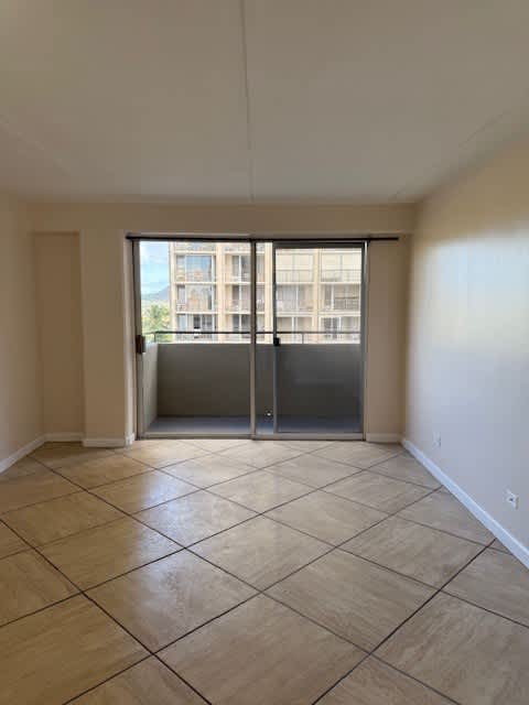 A room with a tiled floor and a view of a building outside through the window.