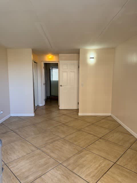 A room with a tiled floor and a white door.