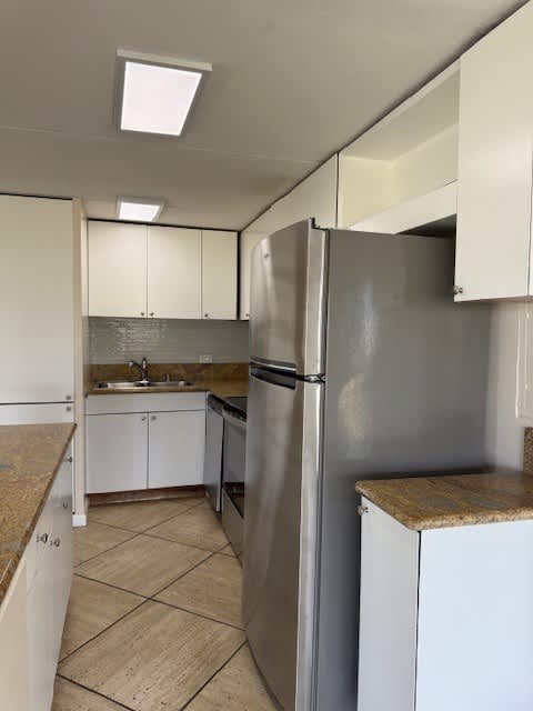 Napili Towers kitchen with a refrigerator, sink, and cabinets.