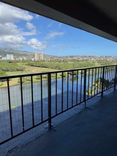 A view from a balcony overlooking a river and a cityscape.