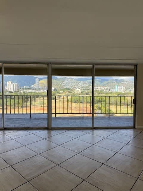 A room with a view of the city through the sliding glass doors.