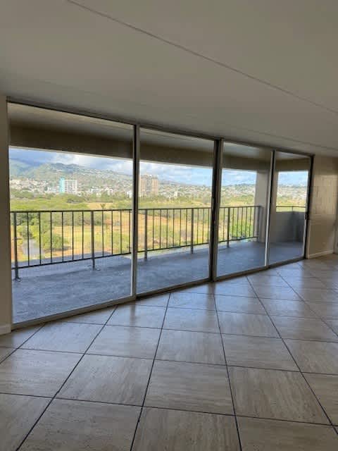 A room with a view of the city through large windows.