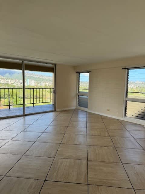 Napili Towers living room with a large tiled floor and sliding glass doors.