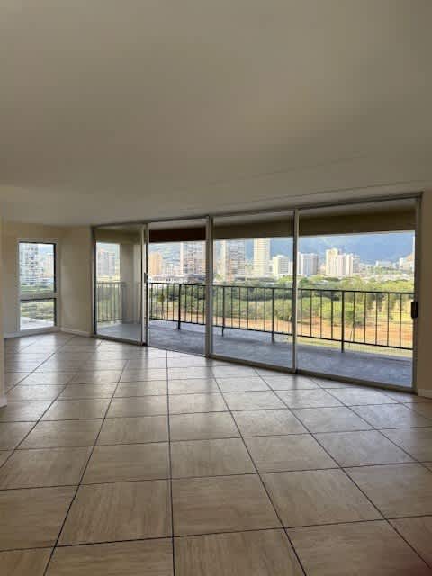 A room with a view of the city through large windows.