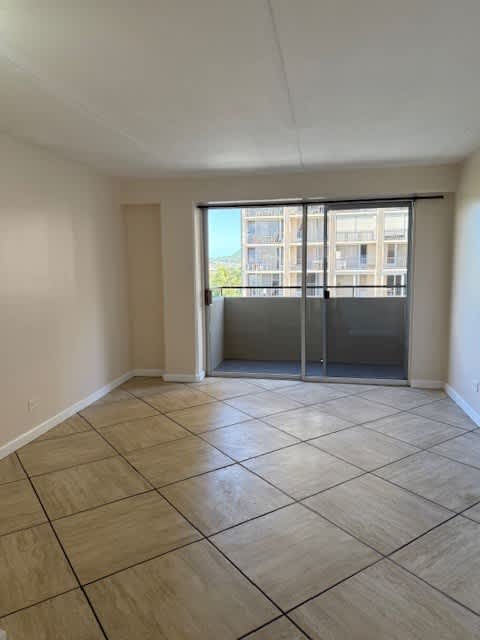 A room with a sliding glass door leading to a balcony.