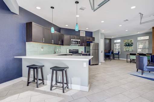 A kitchen with a white counter and bar stools.