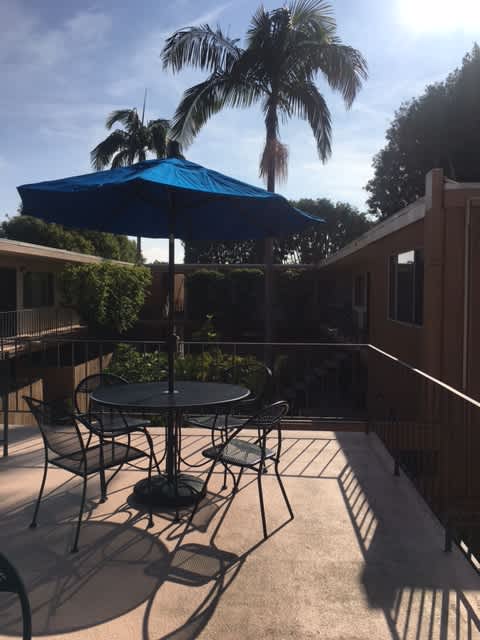 A patio with a table and chairs under an umbrella.