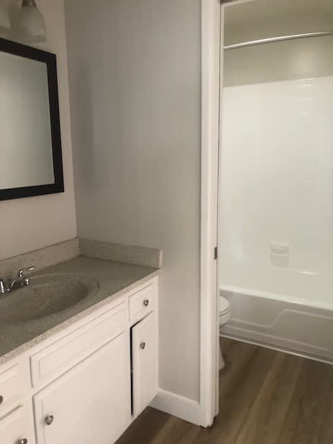 A white bathroom with a sink and mirror.