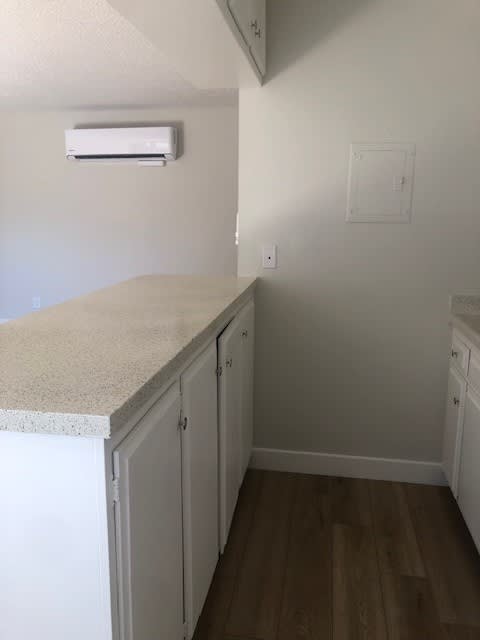 A kitchen with white cabinets and a counter top.