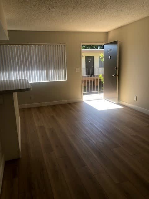 A room with wooden floors and a door leading outside.