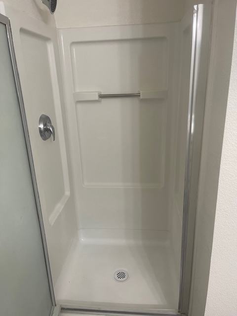 A white sink in a bathroom with a mirror above it.