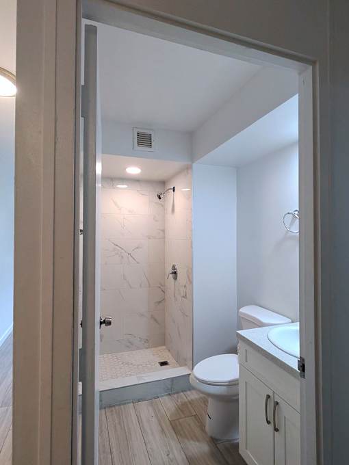Punahou Circle bathroom with a toilet, sink, and walk-in shower.